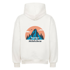 Der Oversized Hoodie "Natur" von MarketPrint ist ein weißer Premium-Kapuzenpullover mit einem Berg, Tannenbäumen, zwei Vögeln und einer orangefarbenen Sonne auf dem Rücken. Unter der Grafik ist der Schriftzug "Natur Mädchen" aufgedruckt, der für einen gemütlichen, stylischen Look sorgt.