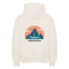 Der Oversized Hoodie "Natur" von MarketPrint ist ein cremefarbener Premium-Kapuzenpullover in Übergröße mit einer Rückengrafik aus Bergen, Bäumen, Vögeln, einer orangefarbenen Sonne und "Natur Mädchen" in Blau und Weiß.