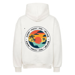 Der MarketPrint Oversized Hoodie "Urlaub" in Weiß zeigt eine große Rückengrafik mit Sonnenuntergang, Meer und Palmen sowie "KOMM * MACH * MAL * URLAUB" im Kreis für eine entspannte Urlaubsatmosphäre.
