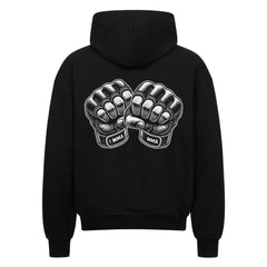 Der MarketPrint Oversized Zipper Hoodie "MMA" ist ein schwarzer Kapuzenpullover mit übergroßer Passform und detaillierten MMA-Handschuhen auf der Rückseite. Er besteht aus 100 % Baumwolle und zeigt eine auffällige Grafik für herausragenden Stil.