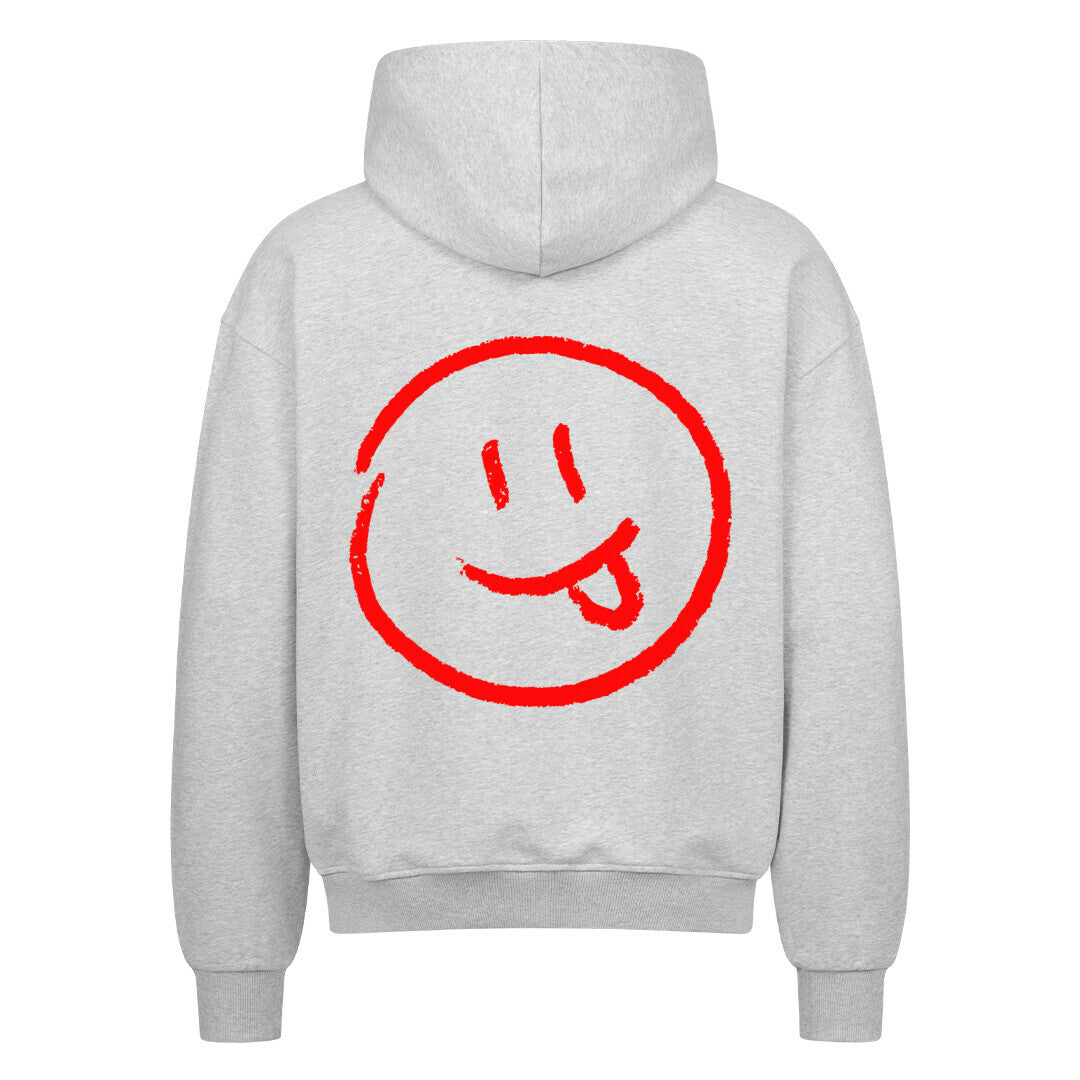 Der Oversized Zipper Hoodie "Smiley" von MarketPrint ist ein hellgrauer Premium-Baumwoll-Kapuzenpullover mit einer großen roten Smiley-Grafik und einem verspielten Gesichtsausdruck auf dem Rücken.