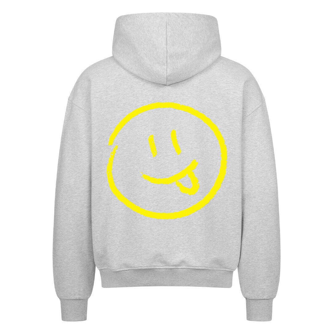 Der MarketPrint Oversized Zipper Hoodie "Smiley" kommt in Hellgrau, zeigt ein großes gelbes Smiley-Gesicht mit herausgestreckter Zunge auf dem Rücken und ist aus 100% Baumwolle für hervorragenden Komfort und Stil gefertigt.