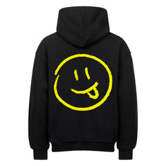 Der MarketPrint Oversized Hoodie "Smiley" ist ein schwarzer Premium-Kapuzenpullover mit einem großen, handgezeichneten gelben Smiley-Gesicht mit herausgestreckter Zunge auf dem Rücken, umrandet von einem gelben Kreis.