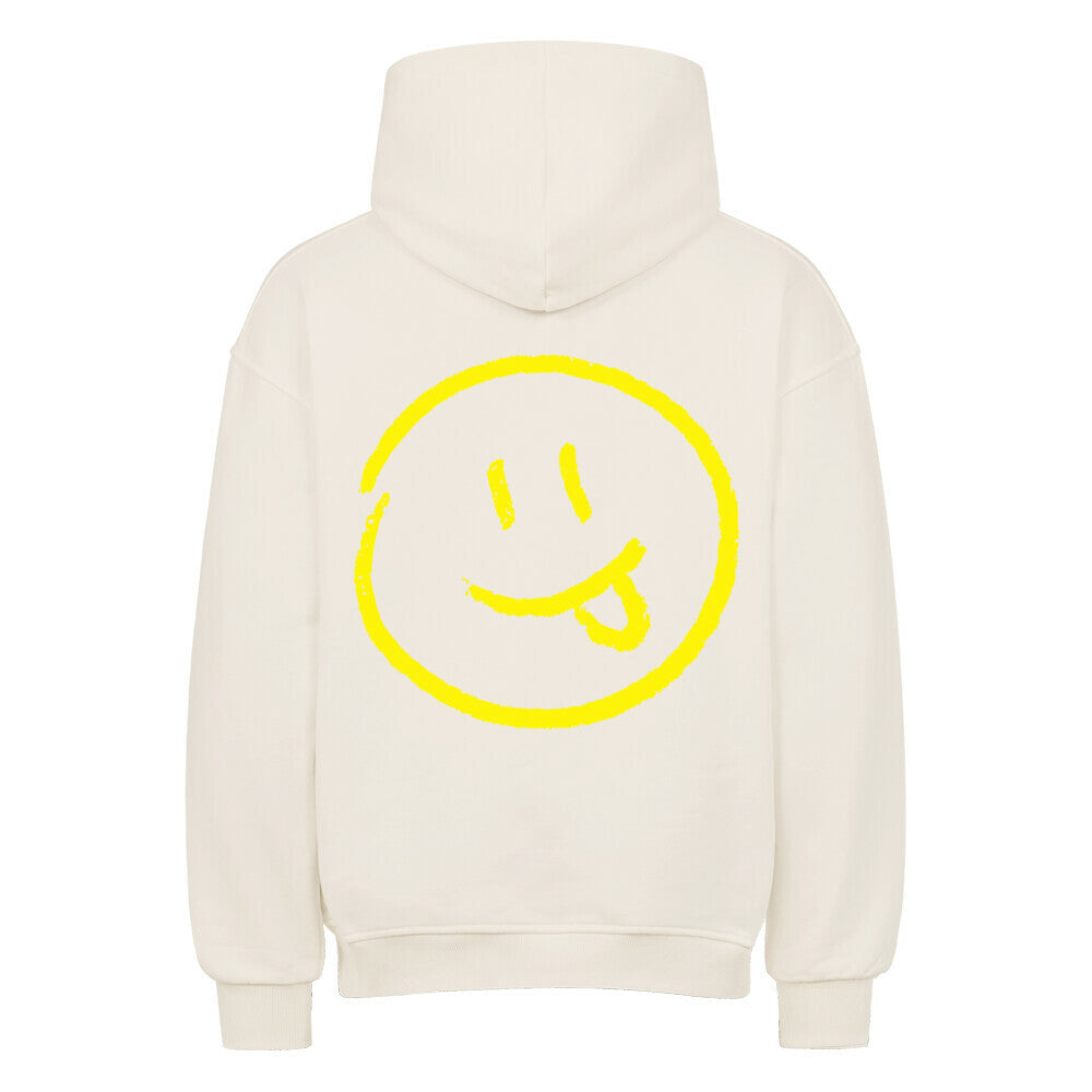 Der MarketPrint Oversized Hoodie "Smiley" ist cremefarben mit einer großen gelben Smiley-Grafik, mit herausgestreckter Zunge, auf dem Rücken.