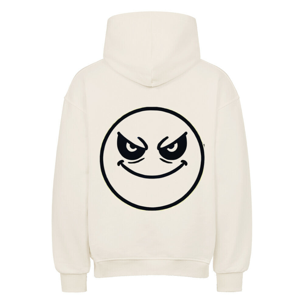 Der Oversized Hoodie "Böser-smiley" von MarketPrint ist cremefarben und zeigt ein großes, schwarz umrandetes, kreisrundes Smiley-Gesicht mit gewölbten Augenbrauen und einem verschmitzten, schelmischen Ausdruck auf dem Rücken.