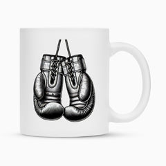 Die MarketPrint Tasse "Box-Handschuhe" ist eine weiße Keramiktasse mit detaillierten schwarz-weißen Boxhandschuhen, die sich dank ihrer hochwertigen Duraglaze-Beschichtung ideal als Sublimationstasse eignet.