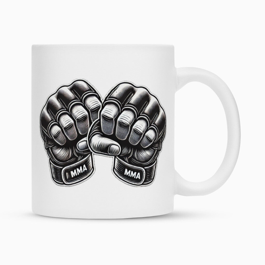 Die MarketPrint Tasse "MMA" ist eine weiße Tasse mit zwei schwarzen MMA-Handschuhen mit geballten Fäusten und dem Schriftzug "MMA" auf den Handgelenkschlaufen - perfekt für Fans.