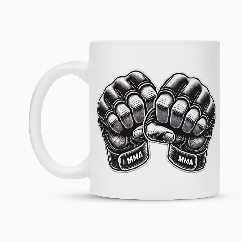Die Tasse "MMA" von MarketPrint ist eine weiße Keramiktasse mit zwei schwarzen MMA-Handschuhen, erhobenen Fäusten und dem Schriftzug "MMA" auf den Trägern - eine stylische Sublimationstasse, perfekt für Kampfsportfans.