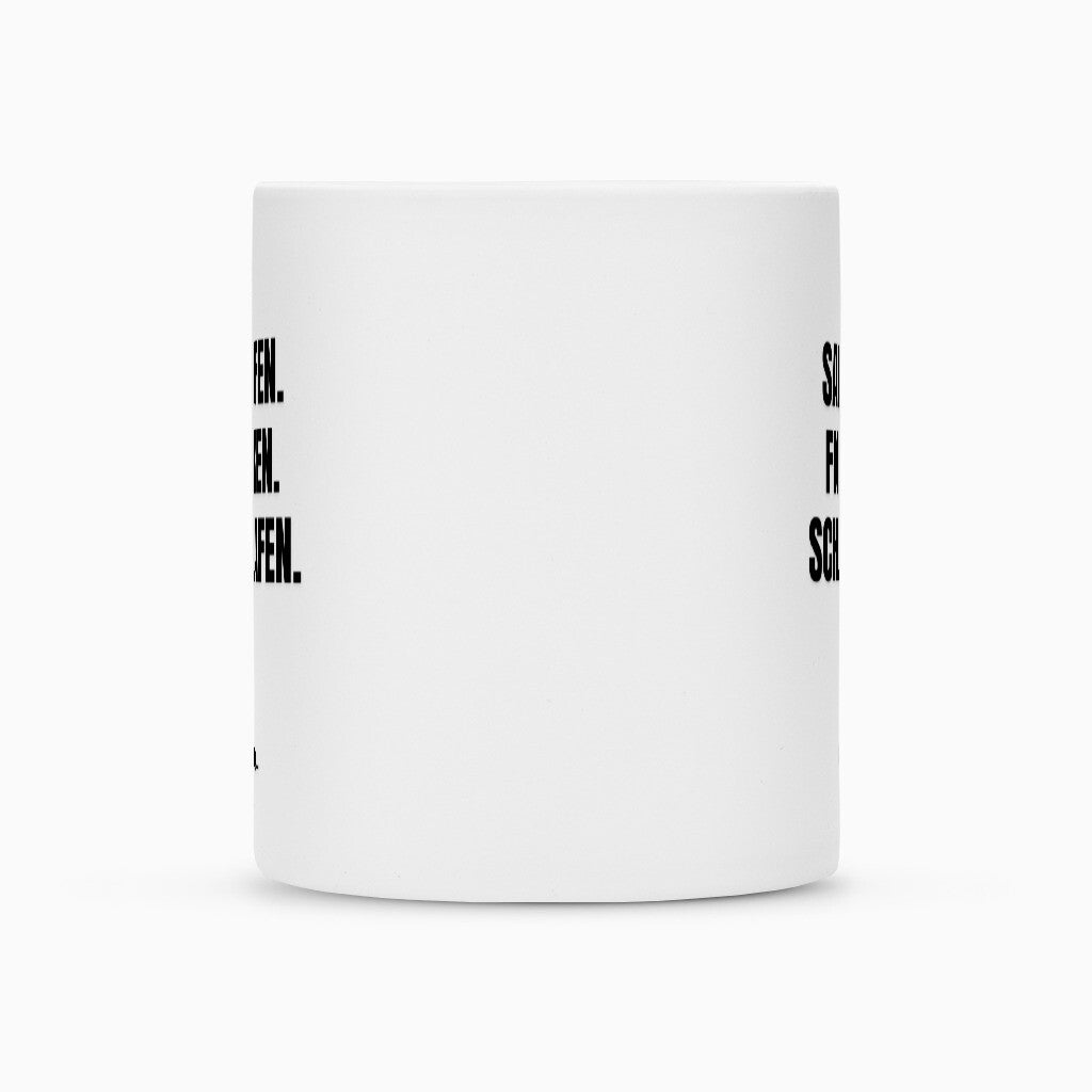 Die weiße Keramik-Tasse "Saufen" von Infinity Merch ist seitlich abgebildet. Am linken und rechten Rand der Tasse sieht man teilweise schwarze Schrift, während die Mitte frei bleibt; der Henkel ist nicht sichtbar.