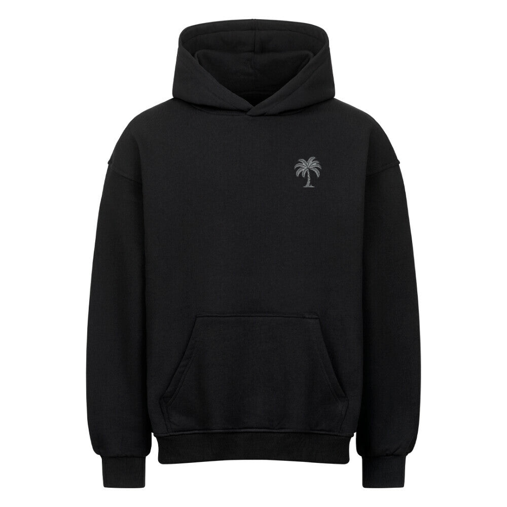 Der Infinity Merch Oversized Hoodie "Strand" ist ein hochwertiger schwarzer Kapuzenpulli mit einer Fronttasche und einer kleinen weißen Palme auf der linken Brust. Er ist aus schwerer Baumwolle gefertigt, die für Komfort und Haltbarkeit sorgt.