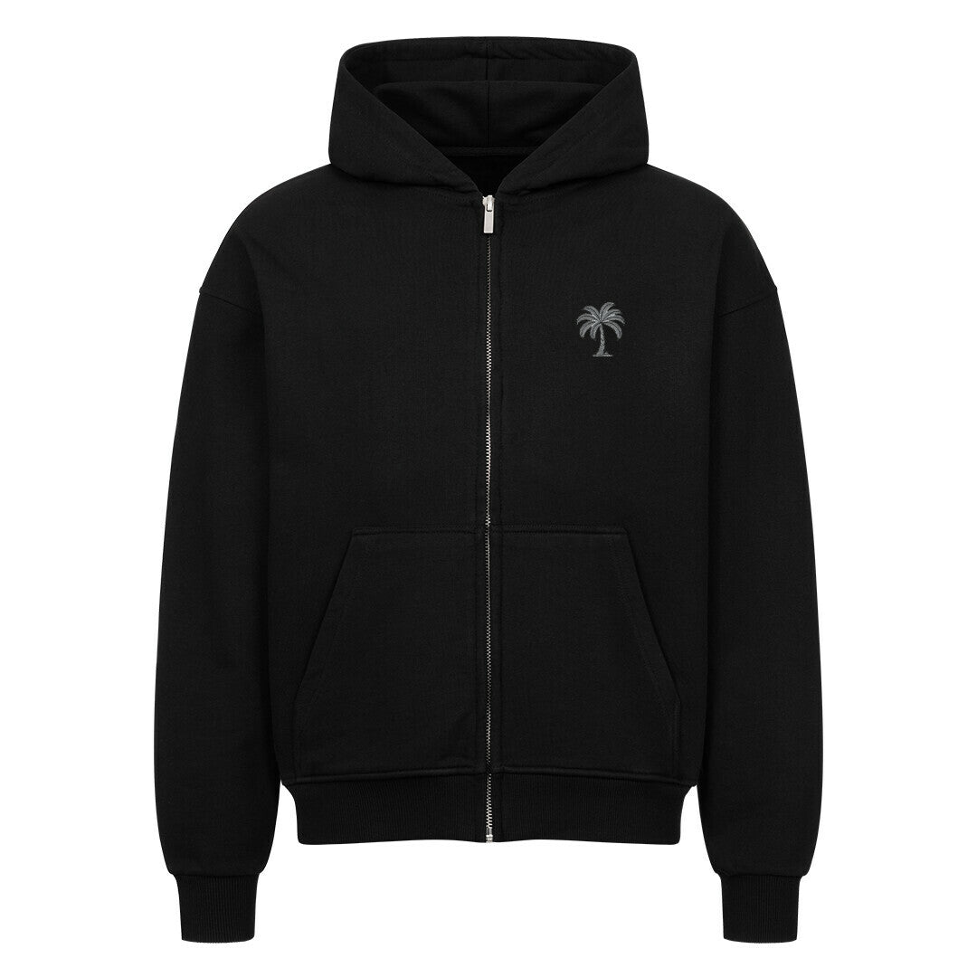 Der Oversized Zipper Hoodie "Strand" von Infinity Merch ist ein schwarzer Premium-Kapuzenpullover mit einer Fronttasche und einer kleinen Palmengrafik auf der linken Brust. Er besteht aus 100% Baumwolle und ist auf weißem Hintergrund abgebildet.