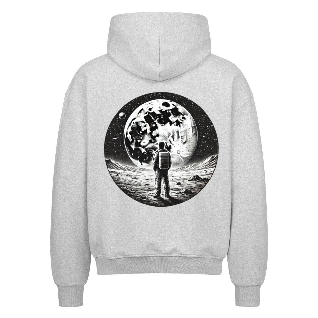 Der Oversized Zipper Hoodie "Astronaut" von Infinity Merch ist ein grauer Kapuzenpullover aus 100% Baumwolle mit einer Astronauten-Illustration auf dem Rücken, die auf einem felsigen Mond unter Sternen und Planeten steht.
